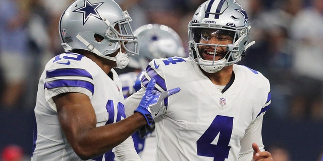 Dak Prescott #4 of the Dallas Cowboys celebrates with Amari Cooper #19 after a touchdown during the fourth quarter against the New York Giants at AT&amp;amp;T Stadium on October 10, 2021 in Arlington, Texas.