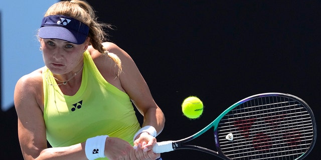 FILE - Dayana Yastremska of Ukraine plays a backhand return to Madison Brengle of the U.S. during their first round match at the Australian Open tennis championships in Melbourne, Australia, Jan. 17, 2022.