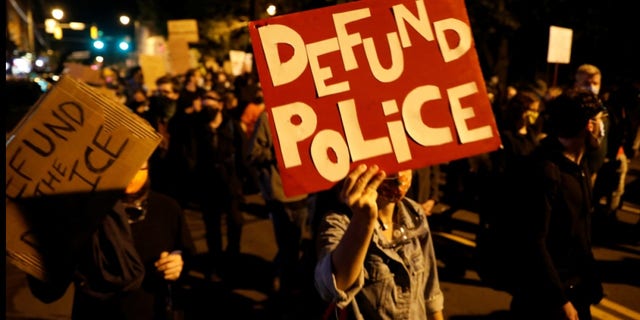 <strong>Demonstrators hold a sign reading "Defund the police" during a protest over the death of a Black man, Daniel Prude, after police put a spit hood over his head during an arrest on March 23, in Rochester, New York, U.S. September 6, 2020. REUTERS/Brendan McDermid</strong>
