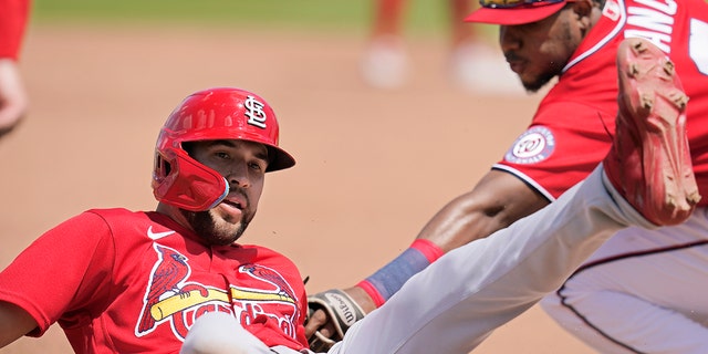 St. Louis Cardinals' Dylan Carlson slides safely into third base as Washington Nationals third baseman Maikel Franco, right, applies the tag on a single by Paul Goldschmidt in the fifth inning of a spring training baseball game, Wednesday, March 30, 2022, in West Palm Beach, Fla. 