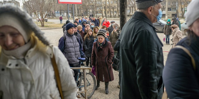 People line up for a food distribution in front of a supermarket in Mykolaiv, on March 14, 2022, on the third week of Russian invasion of Ukraine. 