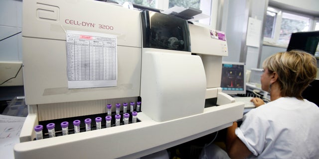 A biologist uses a Cell-Dyn 3200 analyzer, manufactured by Abbott Laboratories, to test blood samples in the medical laboratory of the Casa di Cura San Feliciano hospital in  Rome, Italy, on Monday, July 23, 2012. 