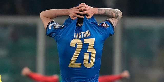 North Macedonia players celebrate as Italy's Alessandro Bastoni reacts after his team's got eliminated at the end of the World Cup qualifying play-off soccer match between Italy and North Macedonia, at Renzo Barbera stadium, in Palermo, Italy, Thursday, March 24, 2022. North Macedonia won 1-0.