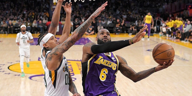 Lakers forward LeBron James shoots against Utah Jazz defenders on Feb. 16, 2022, in Los Angeles.