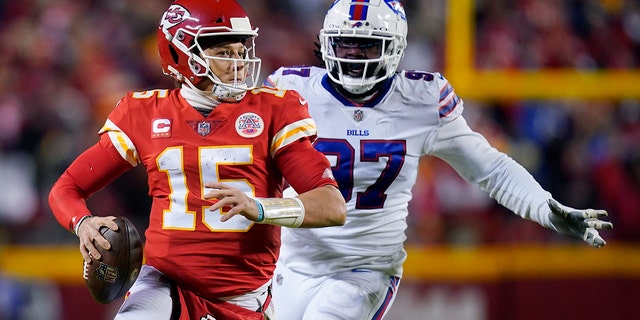 Kansas City Chiefs quarterback Patrick Mahomes (15) is pressured by Buffalo Bills defensive end Mario Addison (97) during the second half of an NFL divisional round playoff football game, Sunday, Jan. 23, 2022, in Kansas City, Mo.