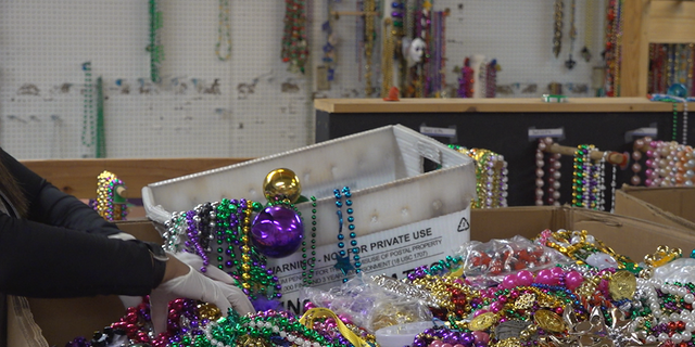 ArcGNO sorts through thousands of boxes of beads for resale for future parades. 