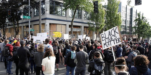Protesters demonstrate outside the Seattle Police Department's East Precinct after the building was boarded up and vacated and people continue rally against racial inequality and the death in Minneapolis police custody of George Floyd, in Seattle, June 8, 2020. 