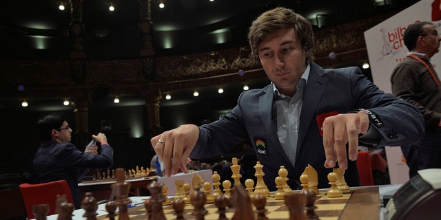 Russian grandmaster Sergey Karjakin adjusts his pieces before a game against Norwegian world chess champion Magnus Carlsen at the IX Chess Masters Final in Bilbao, northern Spain, July 21, 2016.