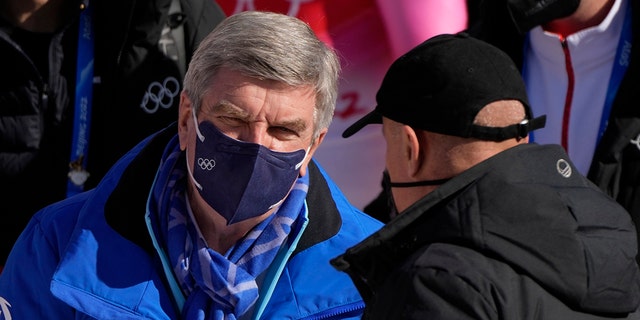 President of the International Olympic Committee, Thomas Bach, left, arrives for the men's downhill at the 2022 Winter Olympics, Monday, Feb. 7, 2022, in the Yanqing district of Beijing.