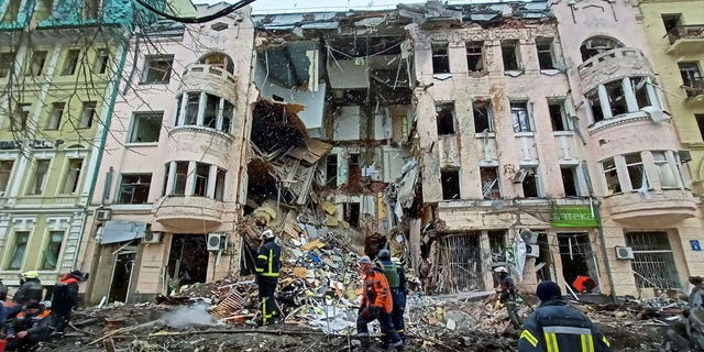 Rescuers work next to a building damaged by air strike, as Russia's attack on Ukraine continues, in central Kharkiv, Ukraine March 14, 2022.