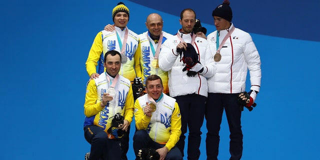 Silver medalist Oleksandr Kazik of Ukraine and his guide Sergiy Kucheryaviy, gold medalist Vitaliy Luk'yanenko of Ukraine and his guide Ivan Marchyshak, and bronze medalist Anthony Chalencon of France and his guide Simon Valverde celebrate during the medal ceremony for Men's 15 km Visually Impaired Biathlon on day eight of the PyeongChang 2018 Paralympic Games on March 17, 2018, in Pyeongchang-gun, South Korea.