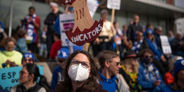 Holly Thorsta, foreground, an art teacher at Roosevelt High, stands in silence with other teachers as Native American leaders honored the land in front of the Davis Center to picket on the 10th day of the teachers strike in Minneapolis, Monday, March 21, 2022. 