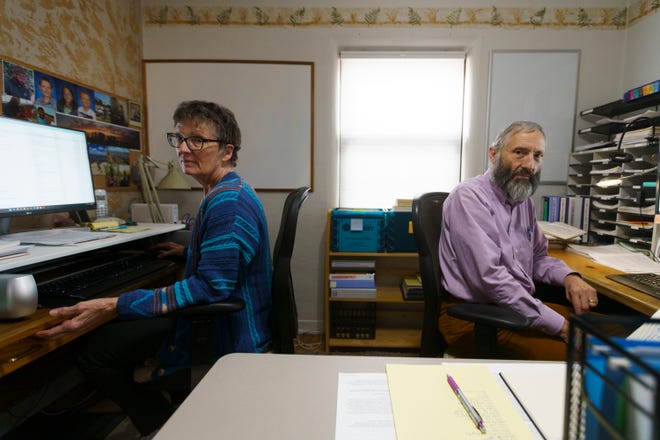 Greg Mello and Trish Williams-Mello sit for a portrait in their office in Albuquerque, N.M.