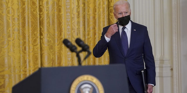 President Biden removes his mask while arriving to speak in the East Room of the White House in Washington, D.C., on Thursday, Aug. 26, 2021.