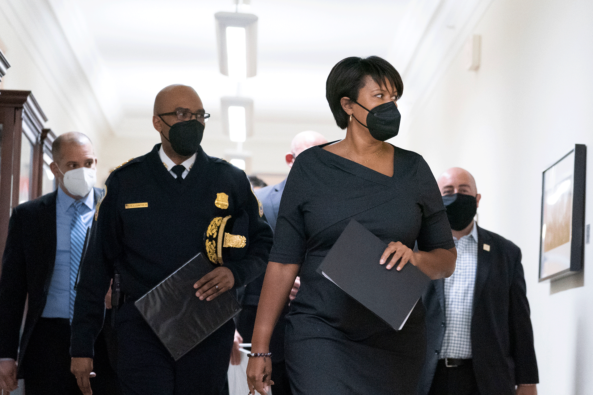 Washington Mayor Muriel Bowser, center-right, walks with Washington Metropolitan Police Chief Robert Contee III, center-left, before a news conference Feb. 28, 2022, in Washington. 