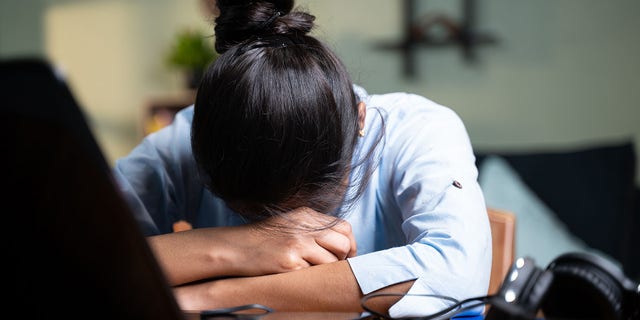 Business woman sleeping by closing laptop while working, concept of new normal burnout, over or late night work at home during coronavirus covid-19 pandemic.