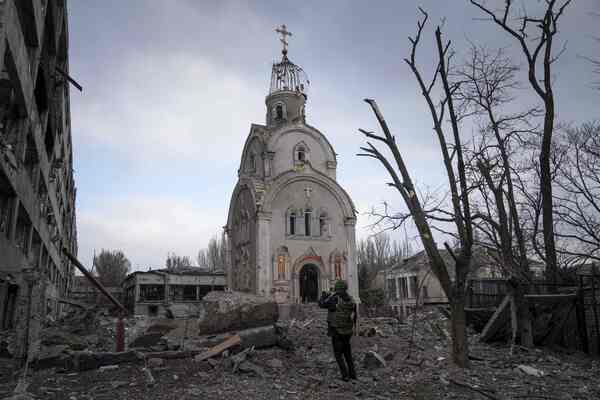 A small church in the middle of a field of debris.