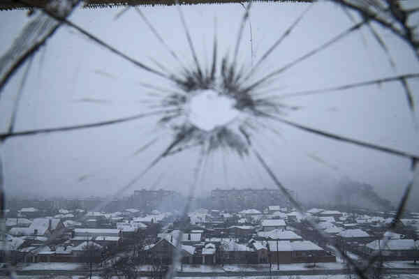 A spiderwebbed window with a circular hole in the center.