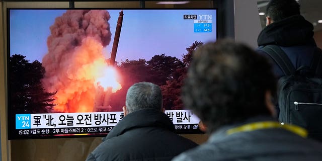 People watch a news program showing a file image of North Korea's rocket launch at the Seoul Railway Station in Seoul, South Korea, Sunday, March 20, 2022. 