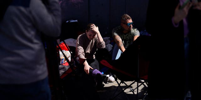 A couple from Russia seeking asylum in the U.S. wait in Tijuana, Mexico, Thursday, March 17, 2022.