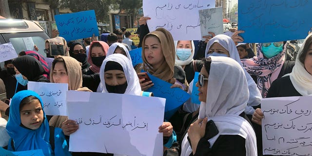 Afghan women chant and hold signs of protest during a demonstration in Kabul, Afghanistan, Saturday, March 26, 2022. Afghanistan's Taliban rulers refused to allow dozens of women to board several flights, including some overseas, because they were traveling without a male guardian, two Afghan airline officials said Saturday. 