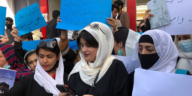 Afghan women chant and hold signs to protest during a demonstration in Kabul, Afghanistan, Saturday, March 26, 2022. Afghanistan's Taliban rulers refused to allow dozens of women to board several flights, including some overseas, because they were traveling without a male guardian, two Afghan airline officials said Saturday. 