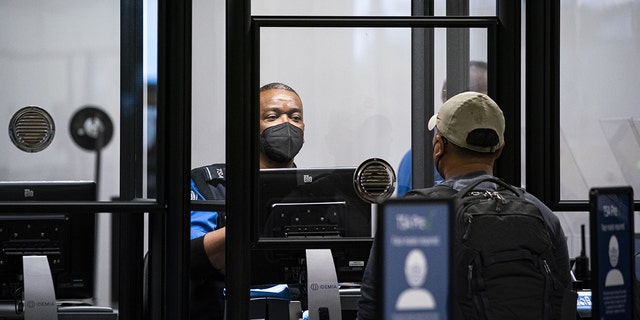 A Transportation Security Administration (TSA) agent screens a traveler at a checkpoint in terminal 2 at Raleigh-Durham International Airport (RDU) in Morrisville, North Carolina, on Thursday, Jan. 20, 2022. 