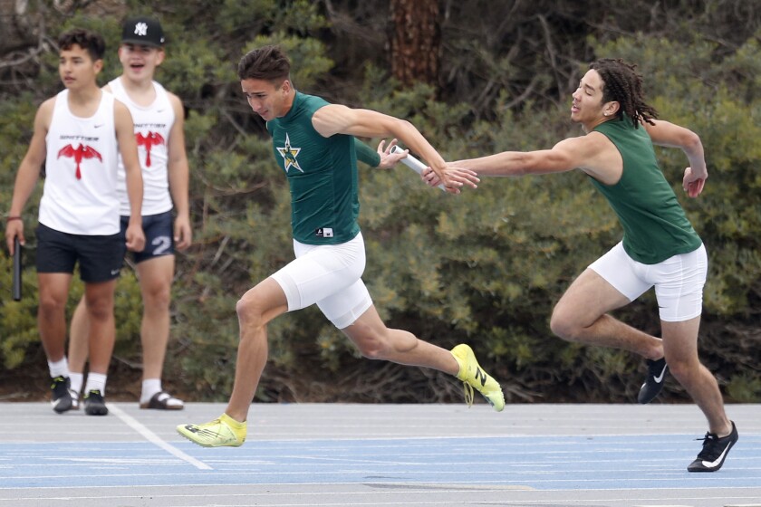 Seth Johnson receives the baton from El Cajon teammate Brent Austin.