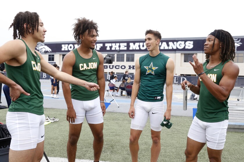 Seth Johnson talks with his 100-meter relay teammates.