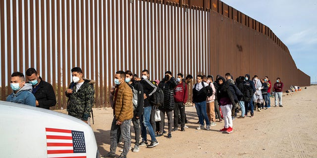 Immigrant men from many countries are taken into custody by U.S. Border Patrol agents at the U.S.-Mexico border on Dec. 7, 2021 in Yuma, Arizona. 