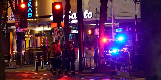 Emergency personnel walk near the scene of an apparent mass shooting in Sacramento, Calif., Sunday, April 3, 2022.