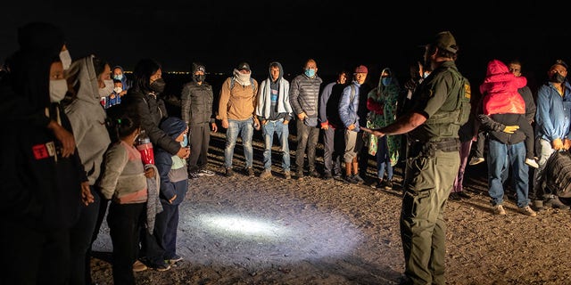 YUMA, ARIZONA - DECEMBER 09:  A U.S. Border Patrol agent speaks with immigrants.