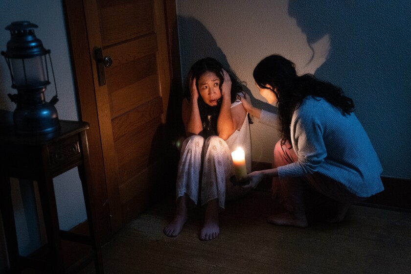 a woman holding a handle checking on a woman crouched on the floor