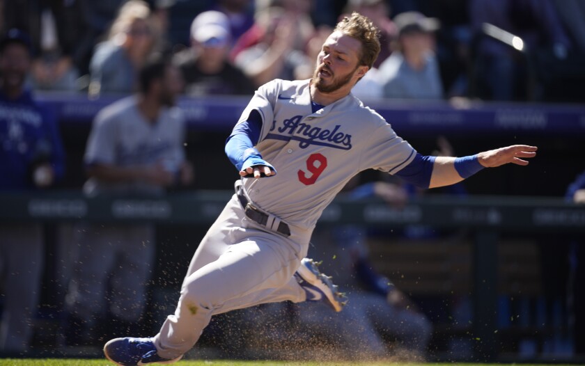 Los Angeles Dodgers' Gavin Lux slides safely into home plate to score on a double hit by Mookie Betts.