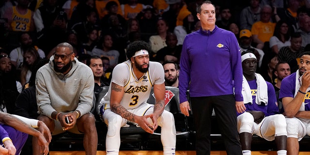 Los Angeles Lakers forward LeBron James, left, sits on the Bech next to forward Anthony Davis as head coach Frank Vogel stands by during the second half of an NBA basketball game against the Denver Nuggets Sunday, April 3, 2022, in Los Angeles.