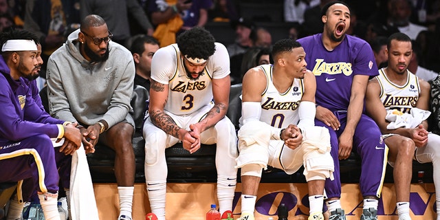 Los Angeles, California April 3, 2022- Lakers players including from left, LeBron James, Anthony Davis and Russell Westbrook sit with teammates on the bench late in the game against the Nuggets at Crypto.com Arena Sunday.