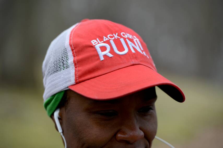 A closeup of Tiffany's head. She wears a red baseball hat that reads 'Black Girls RUN!'