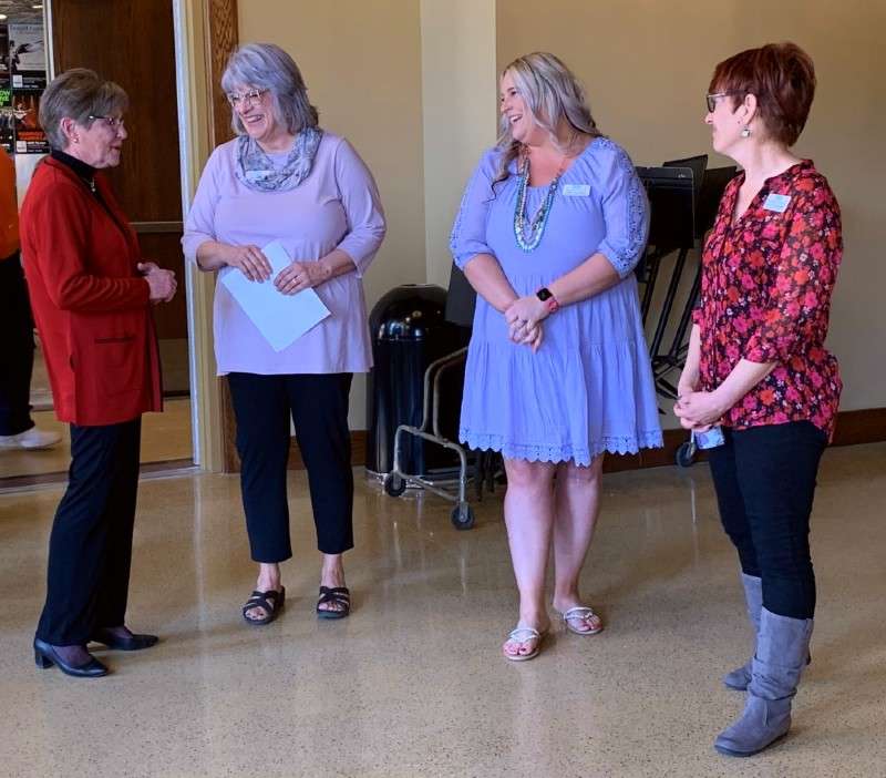 <b>The governor, left, speaks with Leslie Bishop, executive director of Salina Downtown, Inc.,&nbsp;April Rickman, executive assistant/event planner for Salina Downtown, and Dian Gebhardt, downtown aesthetic specialist for Salina Downtown.</b>