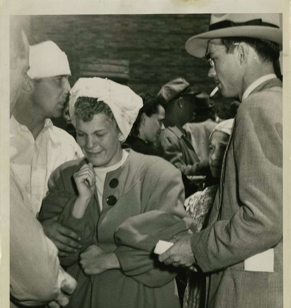 04/17/1947 - Accompanied by her injured friend (left), Robert Gaeway, Nina Faye Adams emerges sobbing from the Texas City emergency morgue. She had just identified the body of her brother.