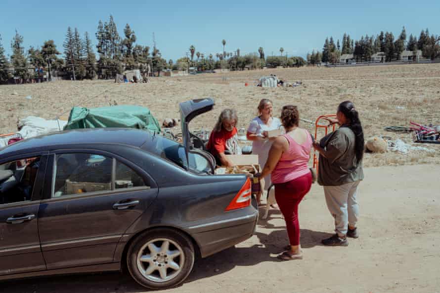 Four women standing by a car