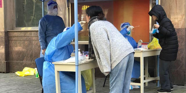 Medical workers conduct mass testing for residents in a lockdown area in the Jingan district of western Shanghai