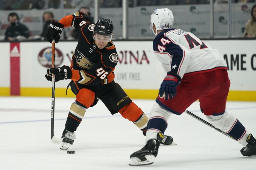 Anaheim Ducks center Trevor Zegras (46) controls the puck against Columbus Blue Jackets defenseman Vladislav Gavrikov.