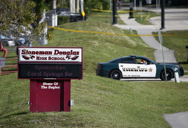 Law enforcement officers block off the entrance to Marjory Stoneman Douglas High School  Feb. 15, 2018 in Parkland, Fla., following a deadly shooting at the school.