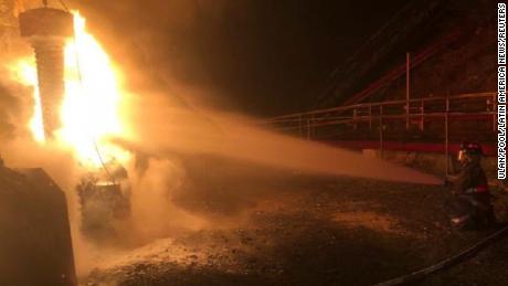 A firefighter battles flames at the Costa Sur power plant Wednesday.