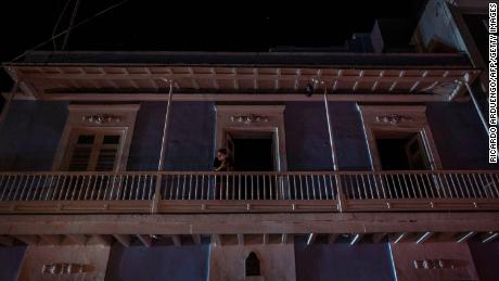 A man stands on a balcony in San Juan after a major power outage hit Puerto Rico Wednesday evening.