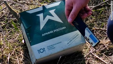 A Ukrainian soldier holds a radiation meter against a Russian military ration pack.