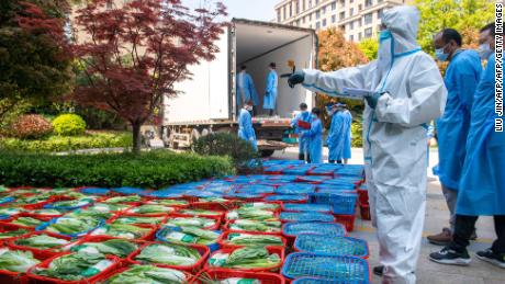 A community volunteer examines vegetables to be distributed to residents under lockdown in Pudong district in Shanghai on April 12.