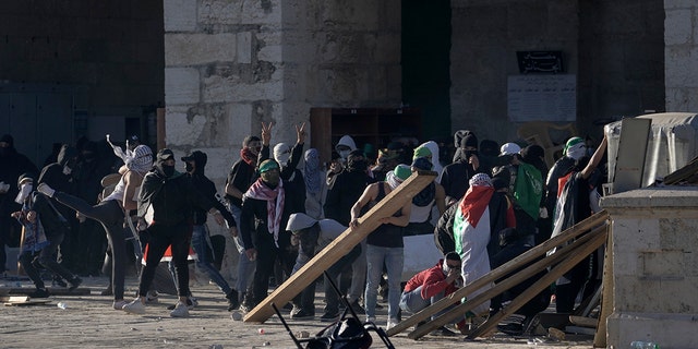 Palestinians clash with Israeli security forces at the Al Aqsa Mosque compound in Jerusalem's Old City Friday, April 15, 2022.