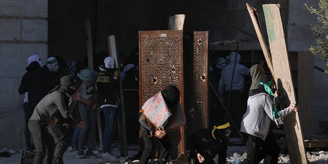 Palestinians clash with Israeli security forces at the Al Aqsa Mosque compound in Jerusalem's Old City Friday, April 15, 2022.