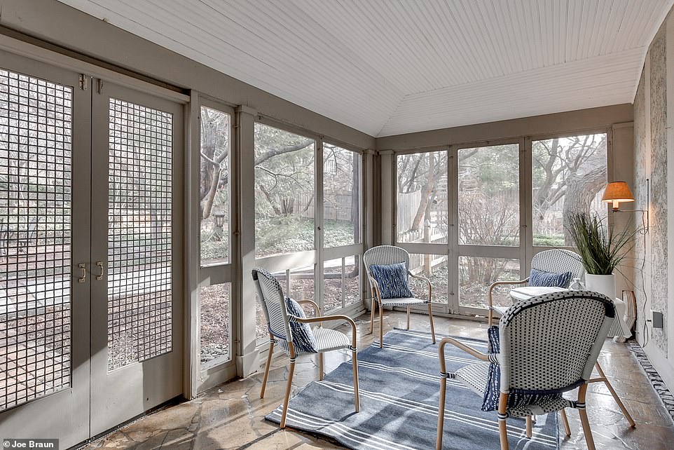 The enclosed patio features enough room for a small selection of chairs looking out into the greenery of the backyard